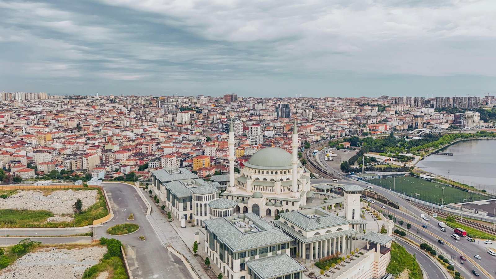 Aerial view of Istanbul showcasing a mosque amidst a vibrant cityscape with cloudy skies.